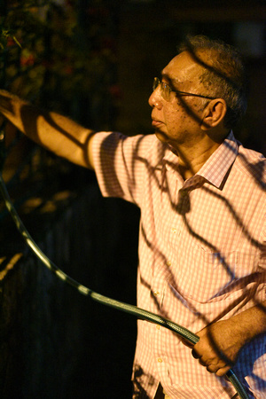 Hussien watering plants at night