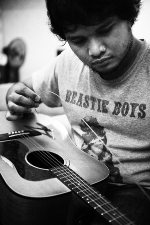 Reza Salleh restringing his guitar