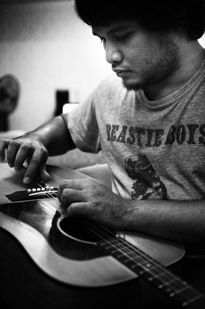 Reza Salleh restringing his guitar